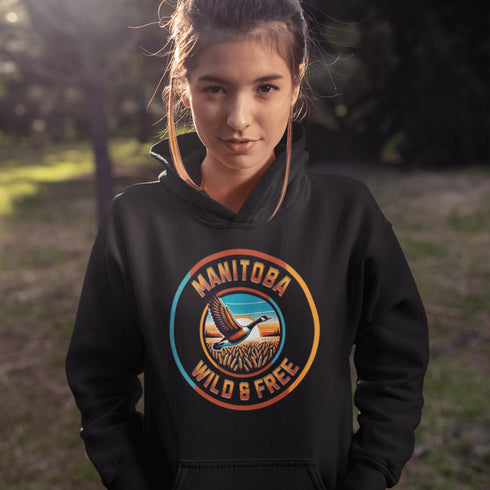 Celebrate the heart of the prairies with our Manitoba – Wild & Free hoodie, featuring a stunning graphic of a Canadian goose soaring over golden wheat fields.